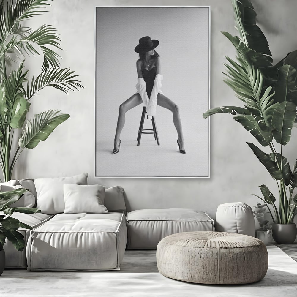 Tablou canvas cu tablou canvas cu femeie pe scaun, in rama de aluminiu argintiu, pe perete intr-un living
